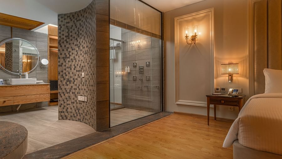 A wide angle shot of a bedroom in our suite with an attached bathroom and a powder room - Sarovar Premiere, Srinagar